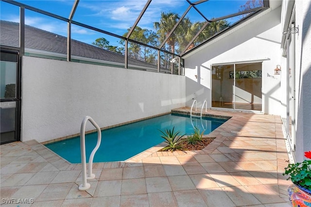 view of swimming pool featuring glass enclosure and a patio area