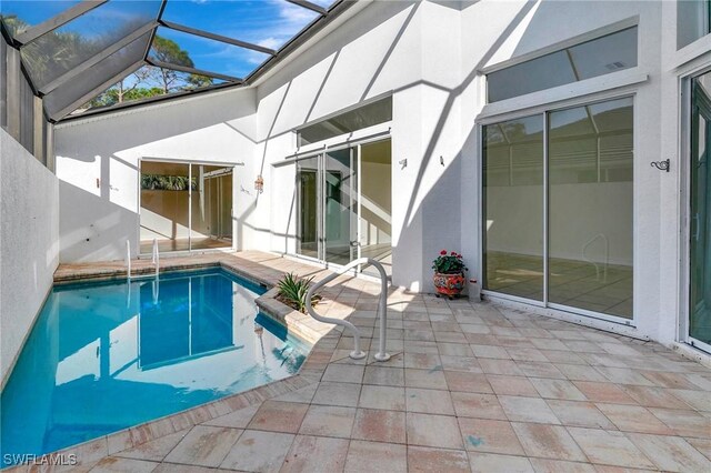 view of swimming pool featuring a patio and glass enclosure