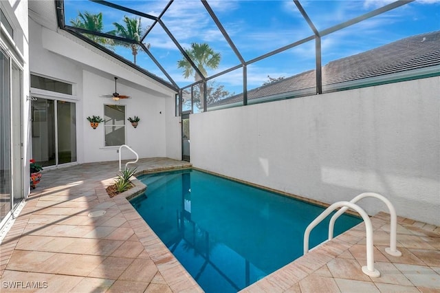 outdoor pool with glass enclosure and a patio