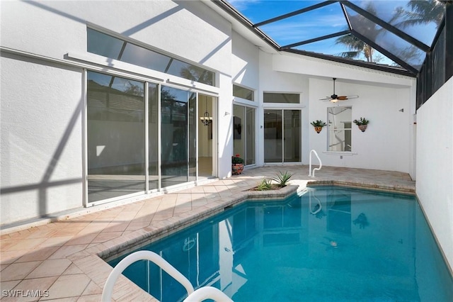 pool featuring a patio, glass enclosure, and a ceiling fan