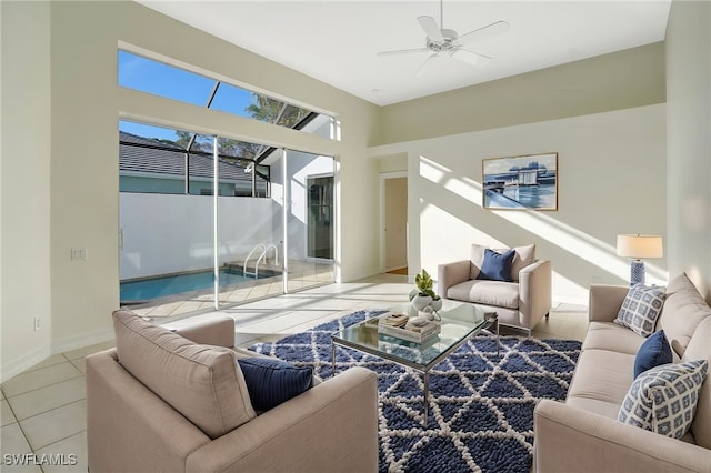 living area featuring baseboards, a ceiling fan, and tile patterned flooring