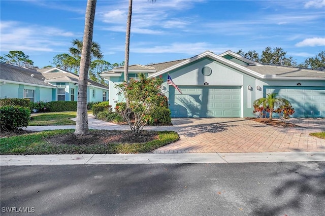 view of front of house featuring a garage, decorative driveway, and stucco siding