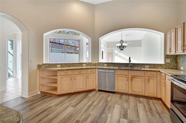 kitchen with light brown cabinetry, stainless steel appliances, light wood-style floors, and a sink