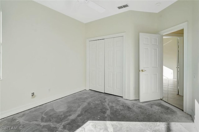 unfurnished bedroom featuring concrete flooring, vaulted ceiling, ceiling fan, and a closet