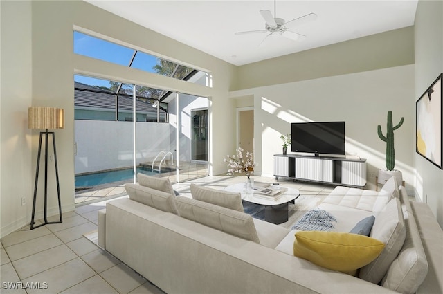 living area with baseboards, ceiling fan, and tile patterned flooring