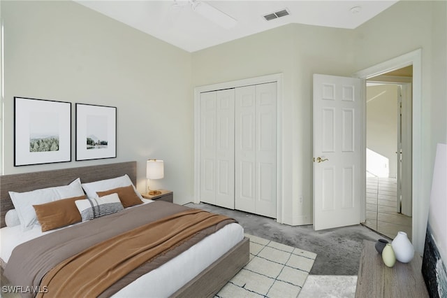 carpeted bedroom featuring lofted ceiling, a ceiling fan, visible vents, and a closet