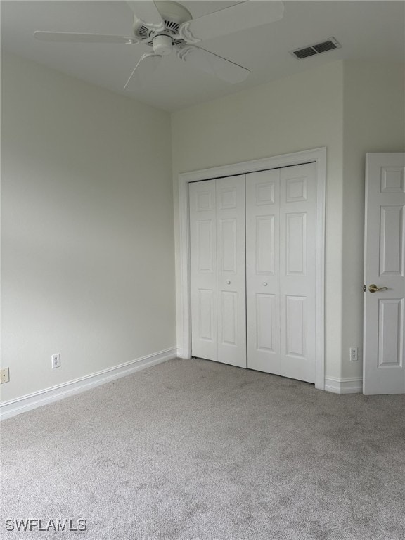 unfurnished bedroom featuring carpet flooring, visible vents, baseboards, a closet, and a ceiling fan