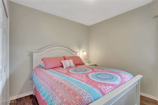 bedroom with dark wood-type flooring