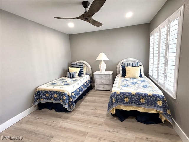 bedroom featuring ceiling fan, baseboards, and wood finished floors