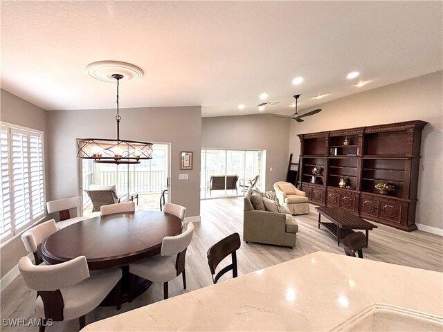 dining area featuring ceiling fan with notable chandelier and light hardwood / wood-style flooring