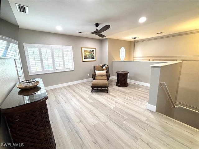 sitting room with ceiling fan and light hardwood / wood-style flooring