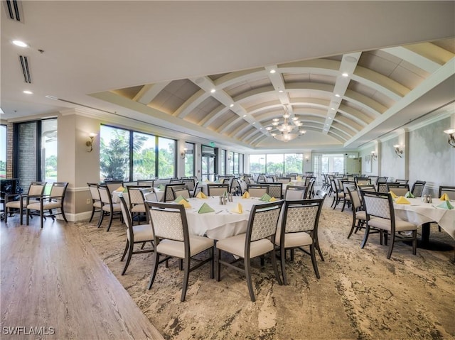 dining room featuring vaulted ceiling, an inviting chandelier, and light hardwood / wood-style flooring