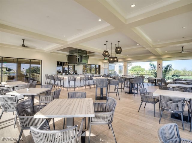 dining room with coffered ceiling, ceiling fan, beamed ceiling, and light wood-type flooring