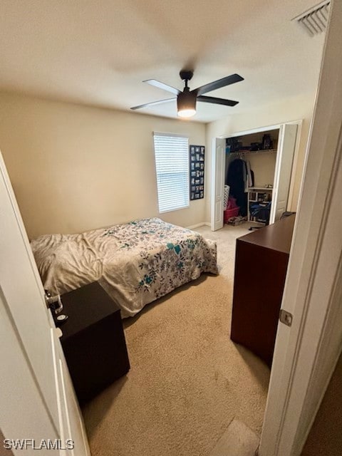 carpeted bedroom featuring ceiling fan and a closet