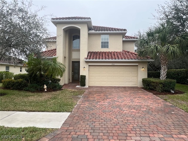 mediterranean / spanish-style house featuring a garage and a front lawn