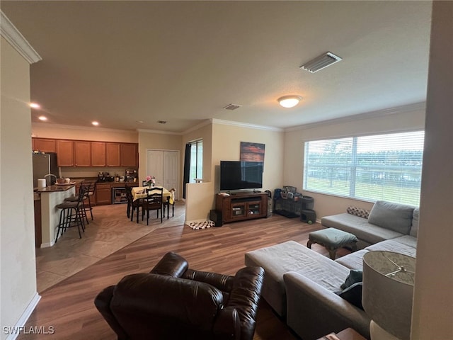 living room with crown molding and light wood-type flooring