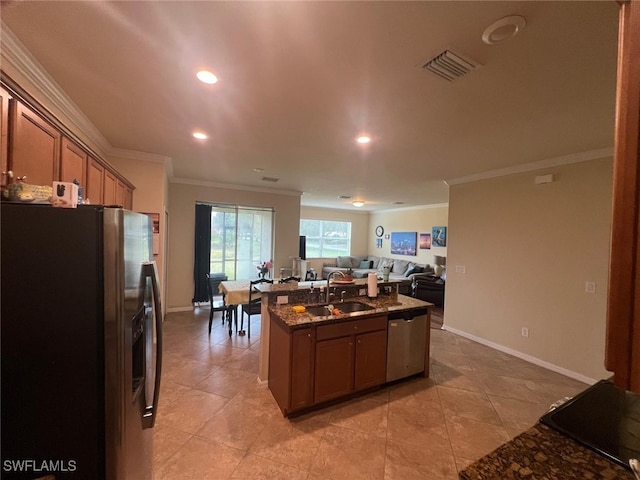 kitchen with sink, crown molding, light tile patterned floors, dark stone countertops, and stainless steel appliances