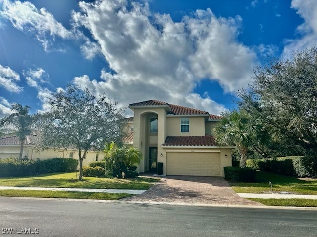 mediterranean / spanish-style house with a garage and a front lawn