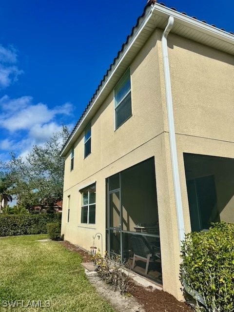 view of side of home with a lawn