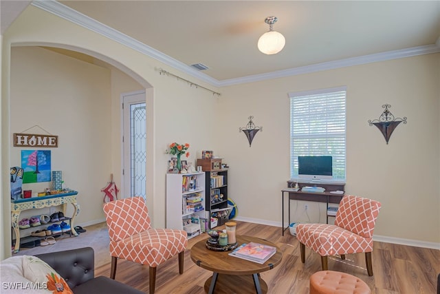 living area with ornamental molding and hardwood / wood-style floors