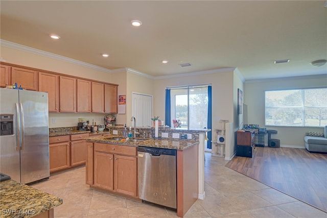 kitchen featuring sink, crown molding, a center island with sink, and appliances with stainless steel finishes