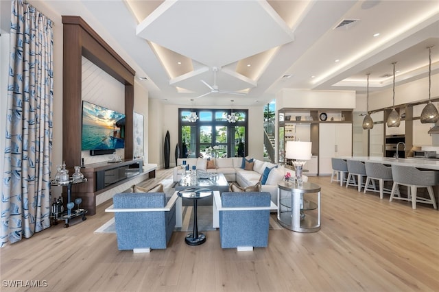 living room with sink, coffered ceiling, and light hardwood / wood-style floors