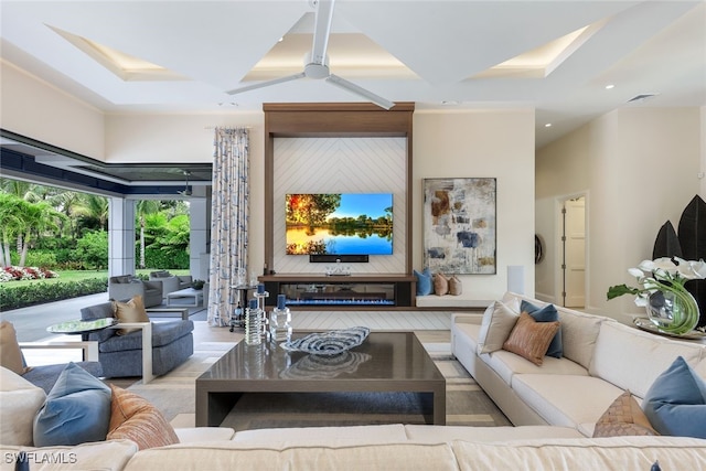 living room with beamed ceiling, coffered ceiling, and ceiling fan