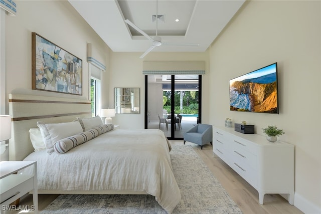 bedroom featuring ceiling fan, access to exterior, light hardwood / wood-style floors, and multiple windows