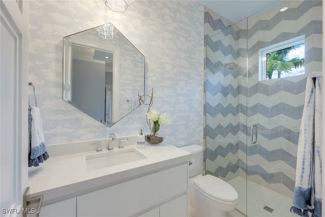 bathroom with an enclosed shower, vanity, and toilet