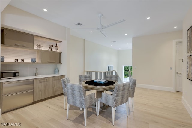 dining area featuring sink, light hardwood / wood-style floors, and ceiling fan