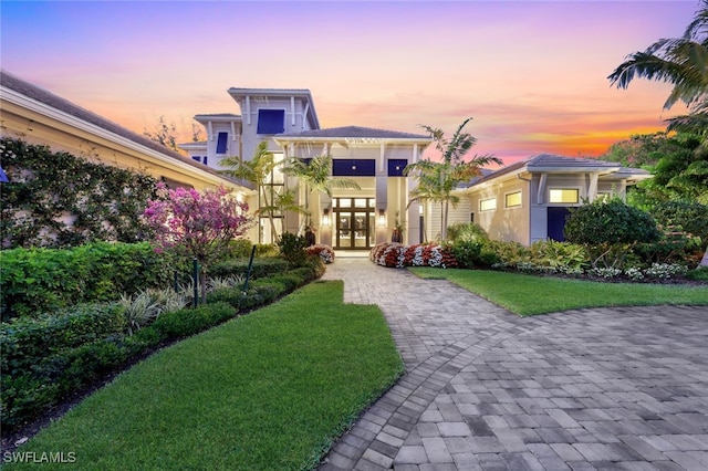 view of front of house featuring french doors and a lawn