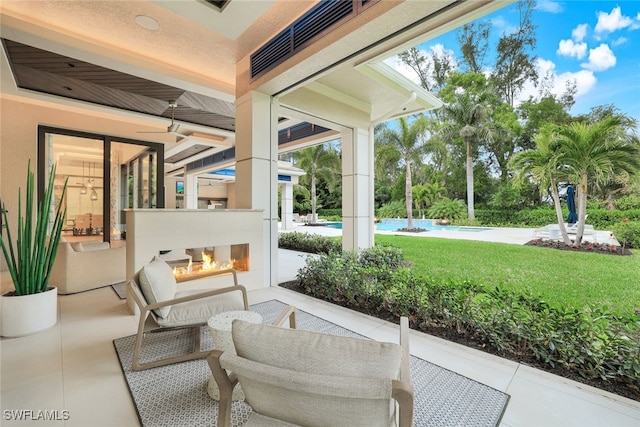 view of patio / terrace with an outdoor fireplace and a swimming pool