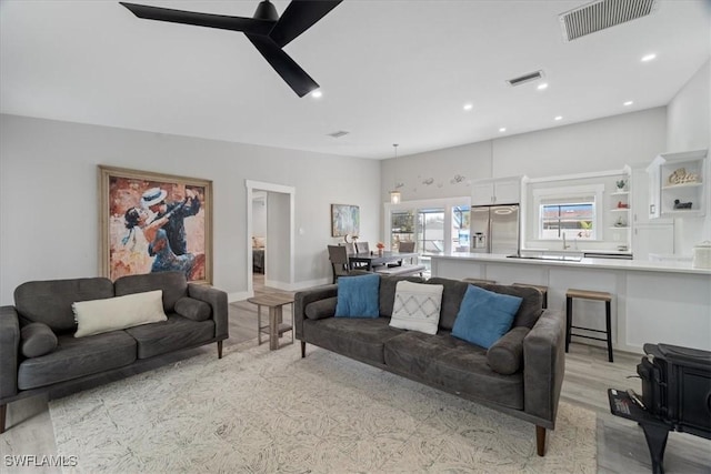 living room featuring light hardwood / wood-style floors and ceiling fan