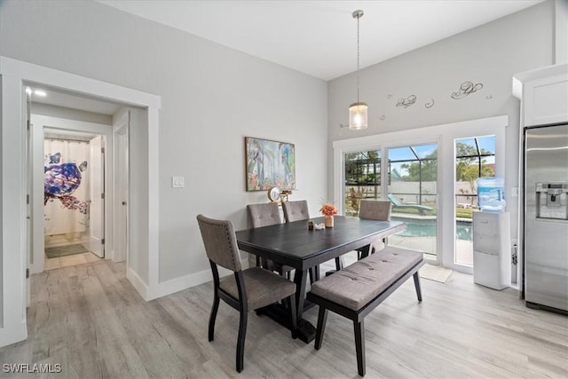 dining space with a high ceiling and light wood-type flooring