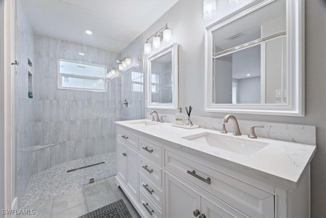 bathroom featuring tiled shower and vanity