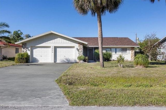 single story home with a garage and a front lawn