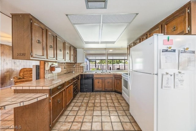 kitchen featuring sink, white appliances, tile counters, decorative backsplash, and kitchen peninsula