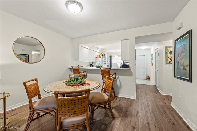 dining room with baseboards and wood finished floors