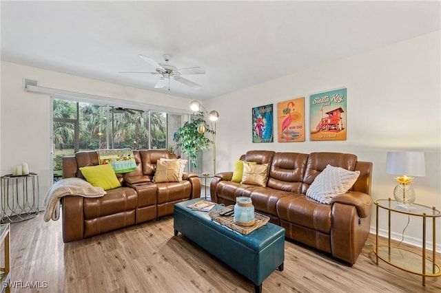 living room with light wood-style flooring, visible vents, baseboards, and a ceiling fan