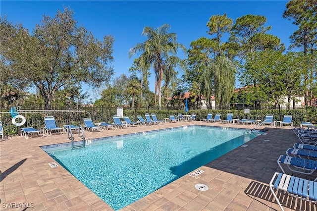 community pool featuring fence and a patio