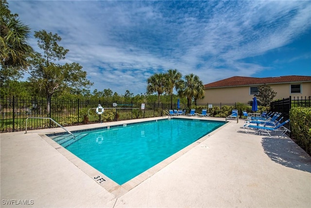 pool with fence and a patio