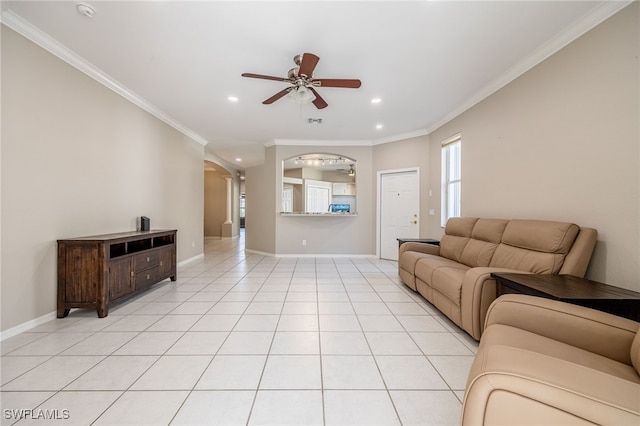 living area with light tile patterned floors, ceiling fan, crown molding, and baseboards