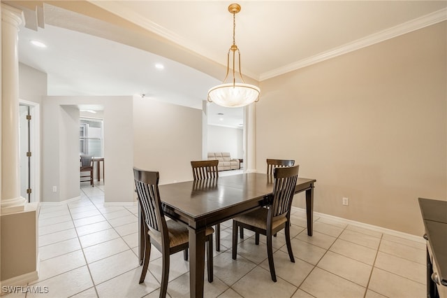 tiled dining space featuring ornate columns and crown molding