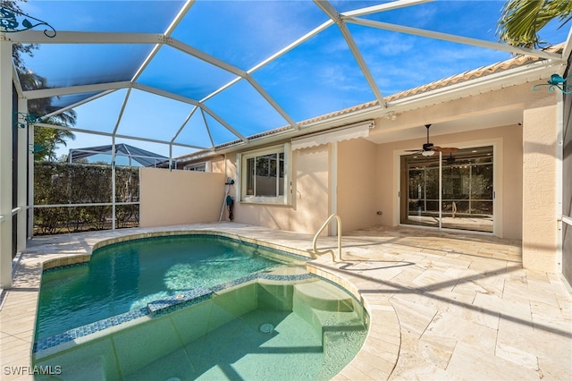 view of swimming pool featuring ceiling fan, glass enclosure, and a patio