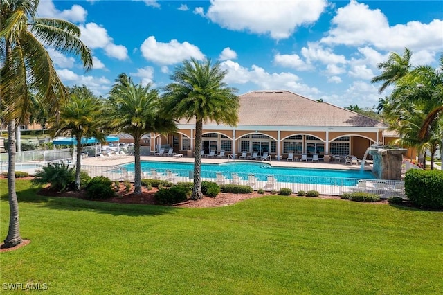 view of pool featuring pool water feature, a patio area, and a lawn