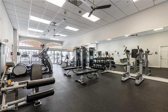 gym featuring a ceiling fan, visible vents, a drop ceiling, and baseboards