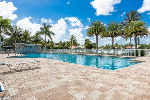 view of swimming pool with pool water feature and a patio area