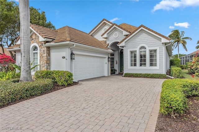 8469 Mallards Way, Naples, FL 34114 - single story home featuring a tile roof, an attached garage, decorative driveway, and stone siding