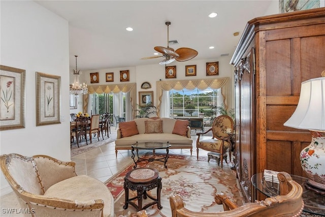 living room with ceiling fan with notable chandelier and light tile patterned floors