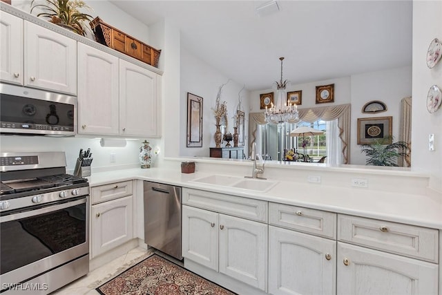 kitchen featuring appliances with stainless steel finishes, kitchen peninsula, sink, and white cabinets